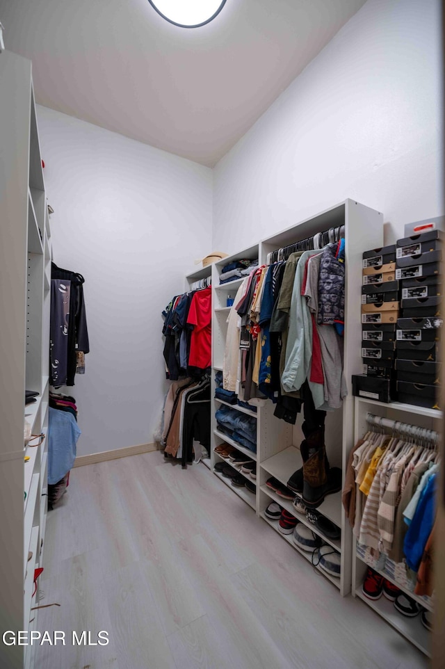 walk in closet with wood finished floors