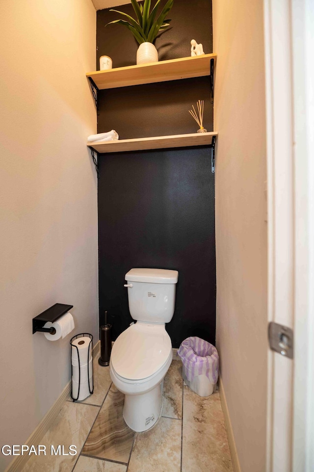 bathroom featuring toilet and baseboards
