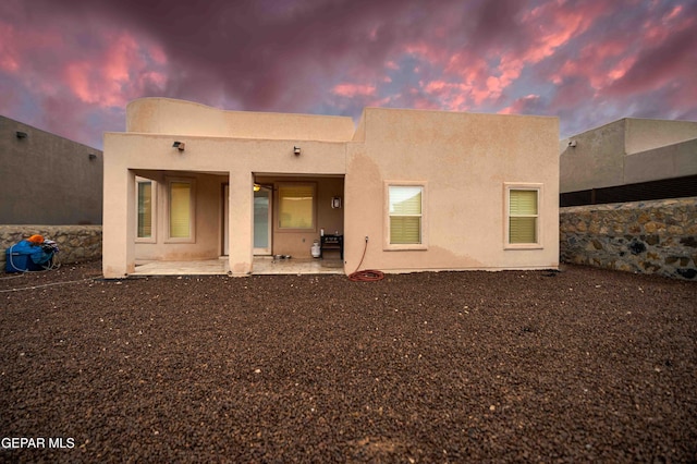 rear view of property with a patio area and stucco siding