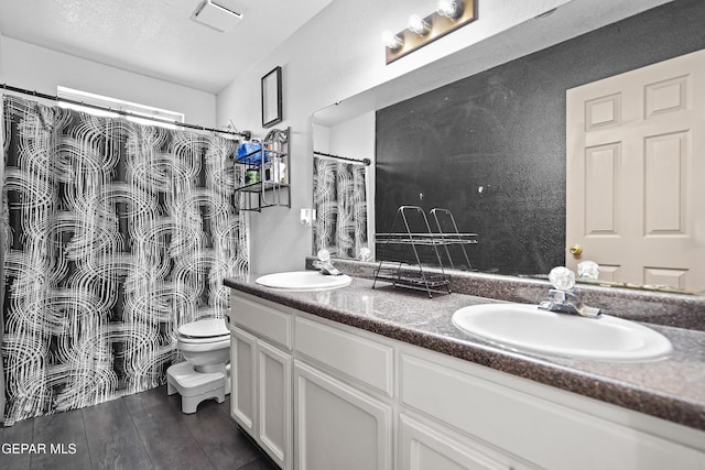 11400 Pifas Nevarez Pl, El Paso, TX 79934 - bathroom with a sink, double vanity, toilet, and wood finished floors
