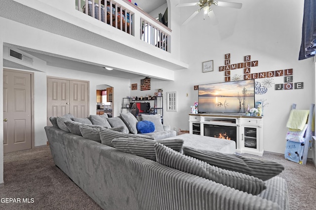11400 Pifas Nevarez Pl, El Paso, TX 79934 - living room featuring arched walkways, carpet, ceiling fan, and a high ceiling