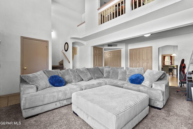 11400 Pifas Nevarez Pl, El Paso, TX 79934 - carpeted living area featuring arched walkways, visible vents, stairway, and a towering ceiling
