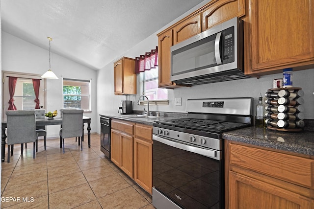 11400 Pifas Nevarez Pl, El Paso, TX 79934 - kitchen featuring hanging light fixtures, appliances with stainless steel finishes, a sink, brown cabinetry, and vaulted ceiling