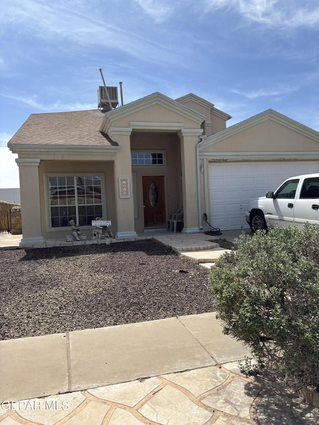 ranch-style house with an attached garage, central air condition unit, and stucco siding