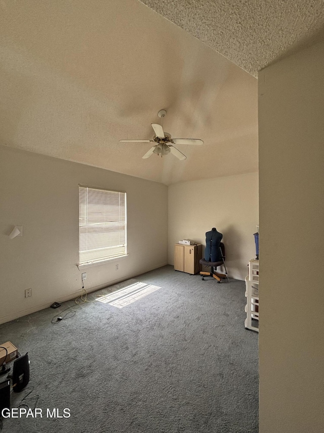 carpeted spare room with ceiling fan and a textured ceiling