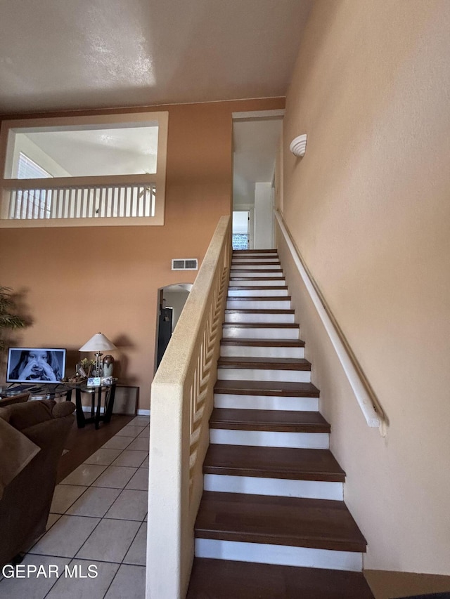 staircase with tile patterned floors and visible vents