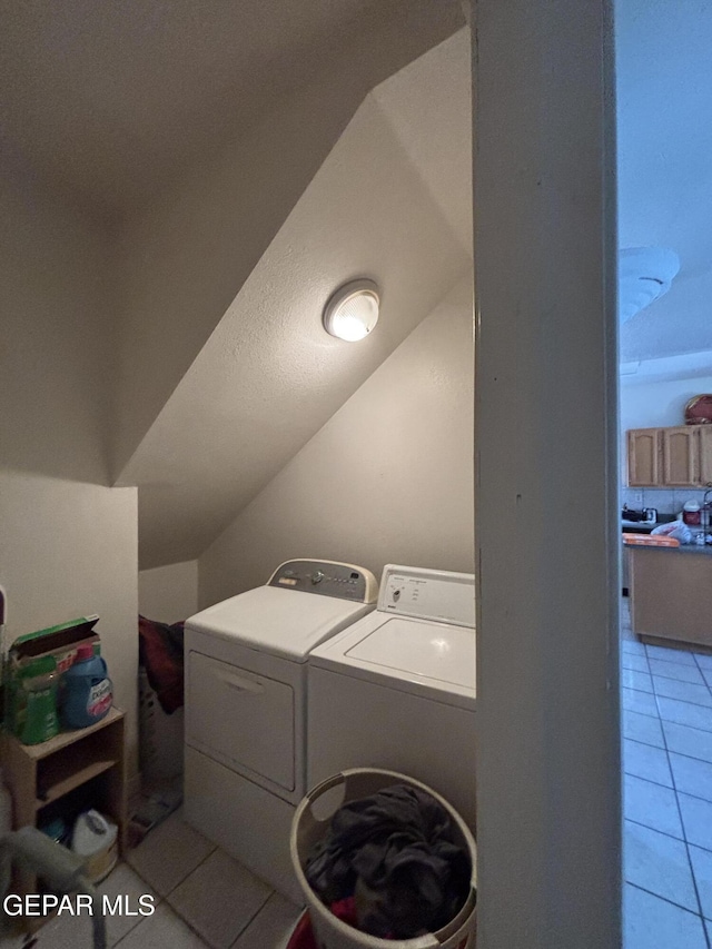clothes washing area with light tile patterned floors, washing machine and clothes dryer, and laundry area