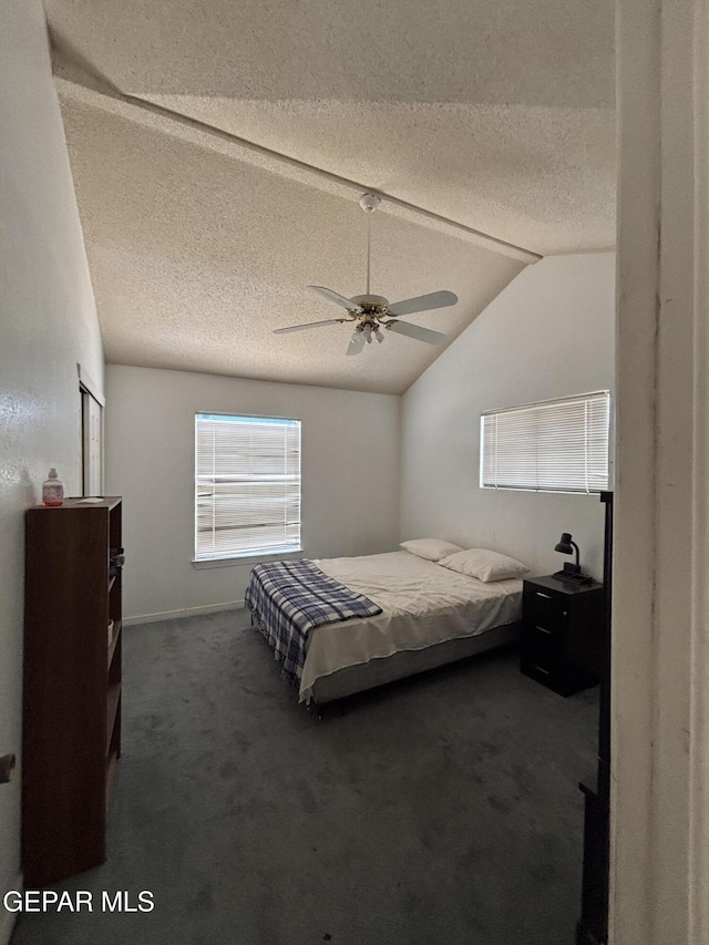 carpeted bedroom with a textured ceiling, a ceiling fan, and vaulted ceiling