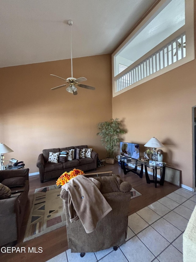tiled living room featuring high vaulted ceiling and ceiling fan