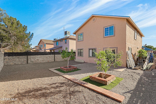 rear view of house featuring stucco siding, a fenced backyard, and a patio