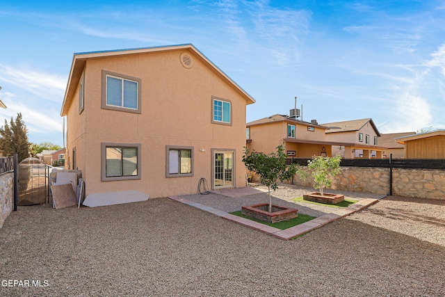 rear view of house featuring a patio area, stucco siding, and a fenced backyard