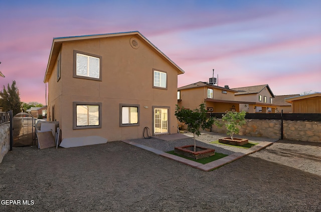 rear view of house featuring stucco siding, a patio area, and a fenced backyard