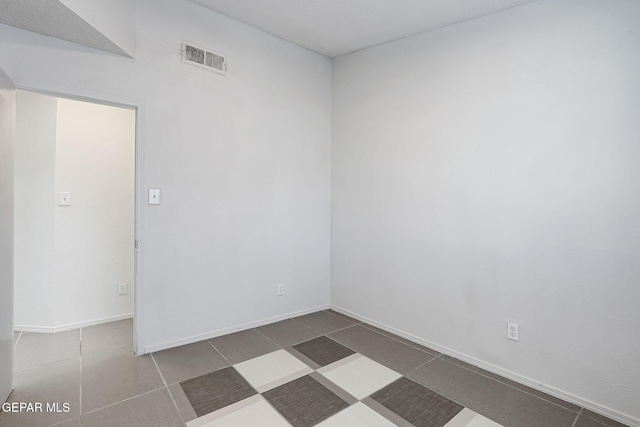unfurnished room featuring baseboards and visible vents
