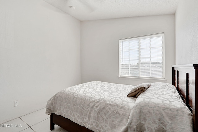 tiled bedroom featuring a textured ceiling