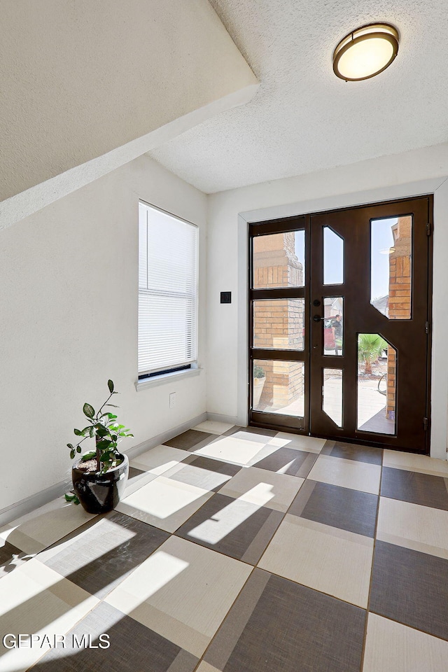 doorway featuring a wealth of natural light and a textured ceiling