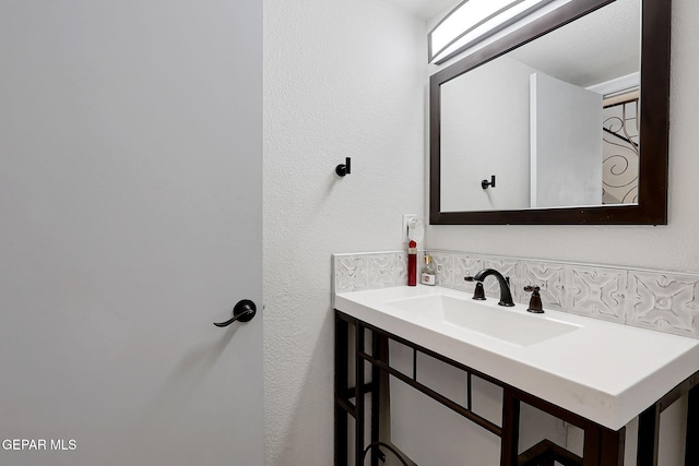 bathroom featuring vanity and a textured wall
