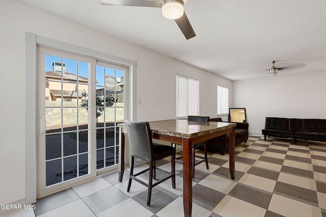 dining area featuring a wealth of natural light, light floors, a ceiling fan, and a textured ceiling