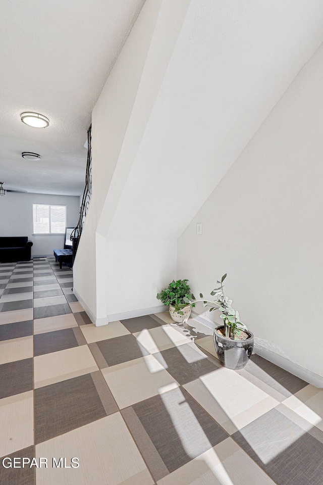 hall featuring carpet flooring and baseboards