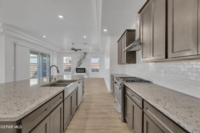 kitchen with recessed lighting, a ceiling fan, stainless steel gas stove, and a sink