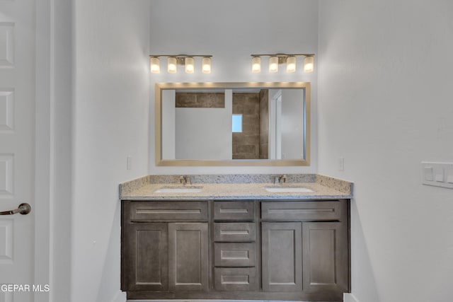 full bath featuring a tile shower, a sink, and double vanity