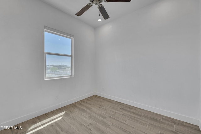 unfurnished room with light wood finished floors, a ceiling fan, and baseboards