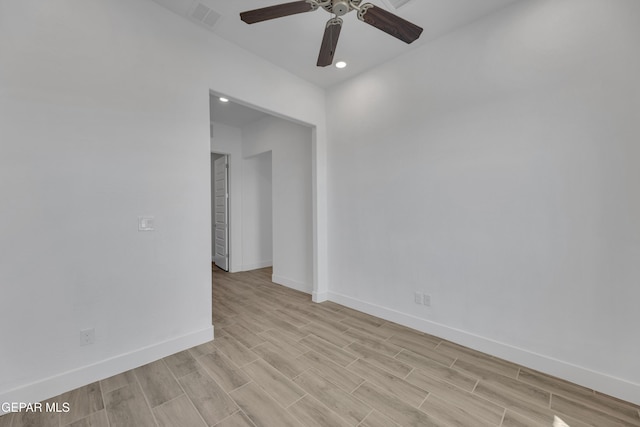 empty room featuring light wood finished floors, baseboards, visible vents, and ceiling fan