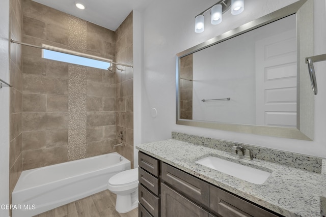 bathroom with toilet, vanity, wood finished floors, and shower / tub combination