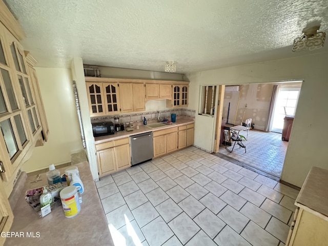 5013 Vulcan Ave, El Paso, TX 79904 - kitchen with dishwasher, light brown cabinetry, a sink, a textured ceiling, and light countertops