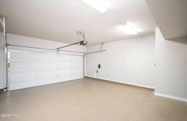 garage with baseboards and a garage door opener
