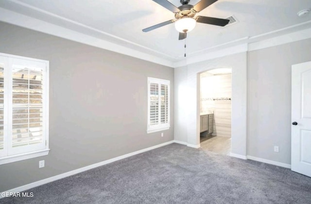 unfurnished bedroom with baseboards, connected bathroom, and carpet