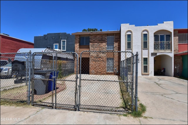 view of front of property featuring fence, stucco siding, and a gate
