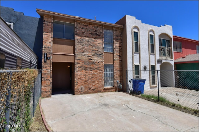 view of front facade with fence and brick siding