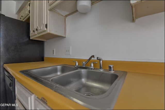 kitchen featuring light countertops, freestanding refrigerator, and a sink
