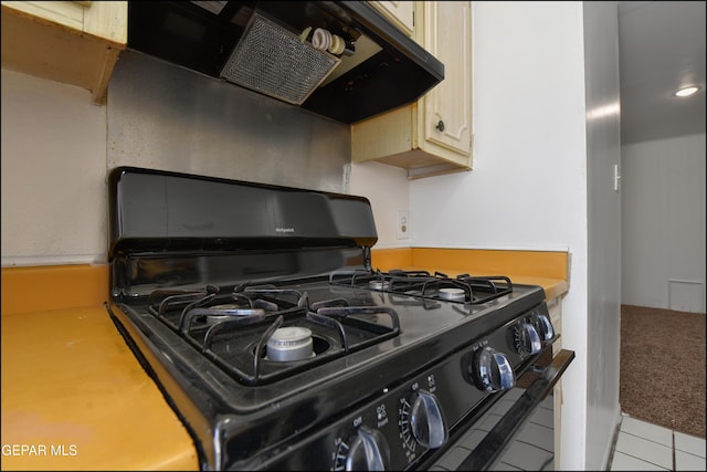 room details with black range with gas cooktop, exhaust hood, and light countertops