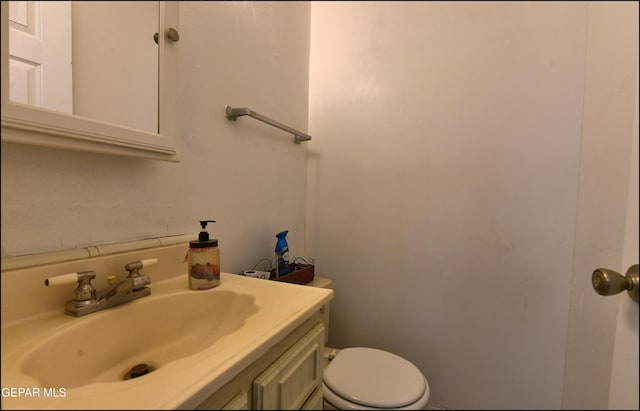 half bathroom with vanity and toilet