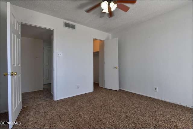 unfurnished bedroom with a textured ceiling, carpet flooring, visible vents, ceiling fan, and baseboards
