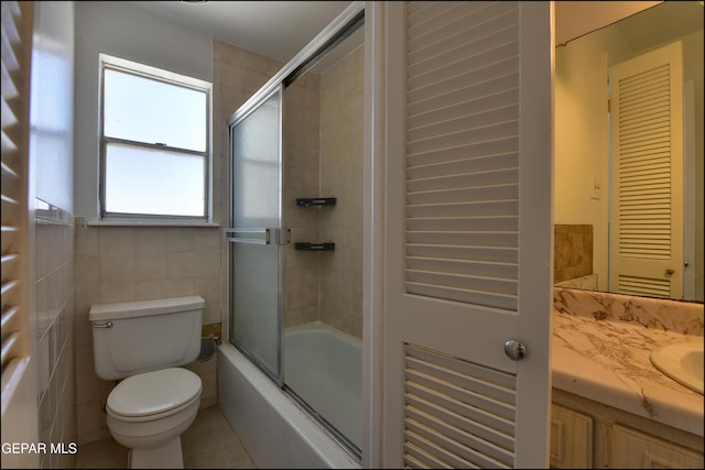 bathroom featuring tile patterned floors, combined bath / shower with glass door, vanity, and toilet