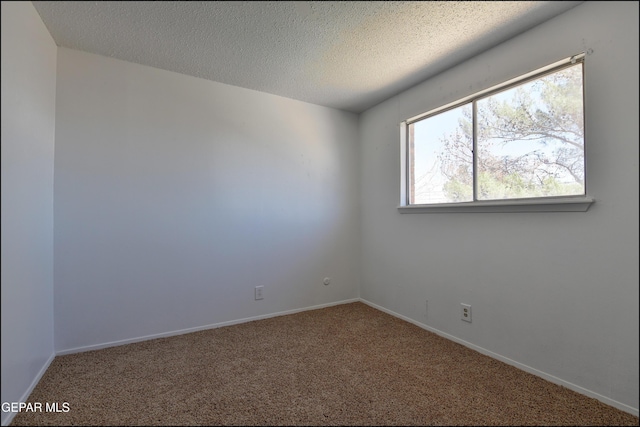 unfurnished room with a textured ceiling, carpet flooring, and baseboards