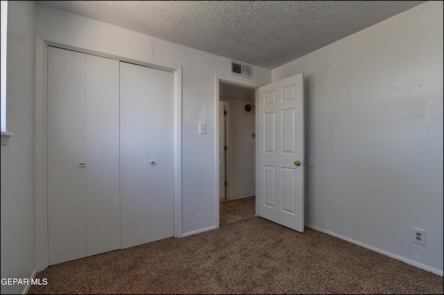 unfurnished bedroom featuring a closet, visible vents, carpet, baseboards, and a textured ceiling