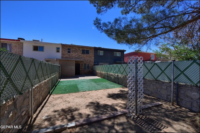 rear view of house with a patio area and a fenced backyard