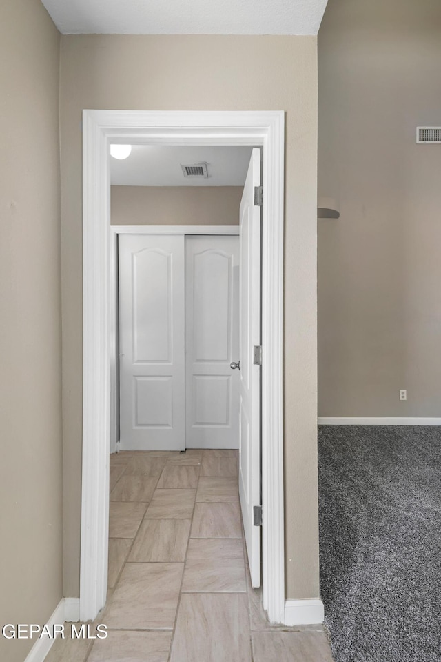 corridor featuring visible vents and baseboards