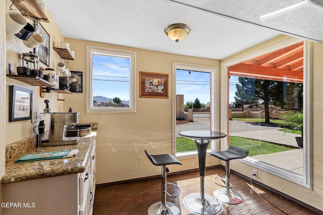 5673 Upper Valley Rd, El Paso, TX 79932 - doorway to outside featuring baseboards, a textured ceiling, wood-type flooring, and a textured wall