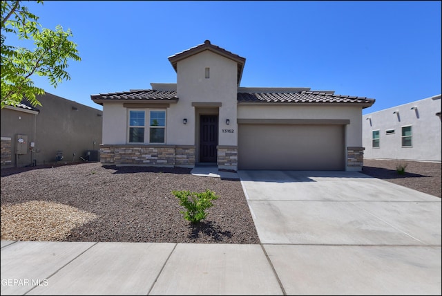 13162 Cleethorpes St, El Paso, TX 79928 - mediterranean / spanish home with stucco siding, a tiled roof, a garage, driveway, and stone siding