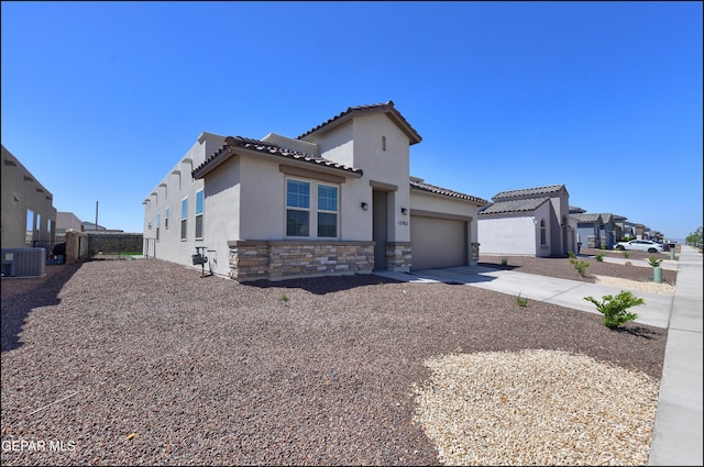 13162 Cleethorpes St, El Paso, TX 79928 - view of front of house featuring stucco siding, central AC unit, a tile roof, stone siding, and concrete driveway