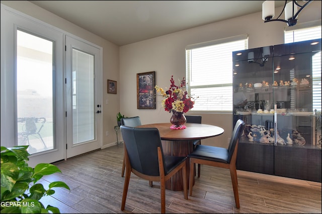 13162 Cleethorpes St, El Paso, TX 79928 - dining room featuring an inviting chandelier, wood finished floors, a healthy amount of sunlight, and baseboards