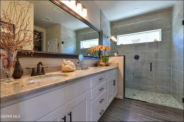 13162 Cleethorpes St, El Paso, TX 79928 - bathroom with wood finished floors, double vanity, a sink, visible vents, and a stall shower