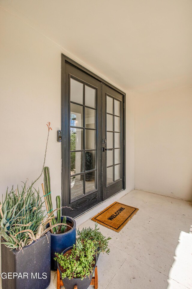 doorway to property featuring stucco siding and french doors