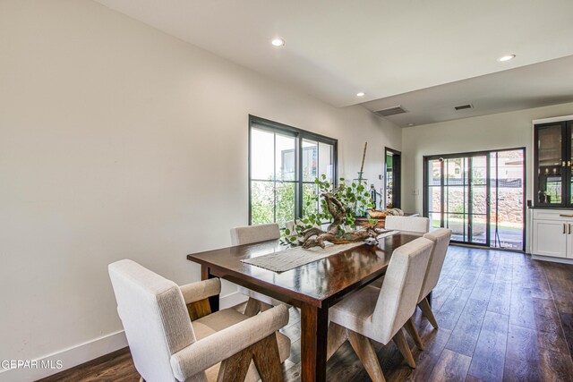 dining room with recessed lighting, visible vents, a wealth of natural light, and dark wood-type flooring