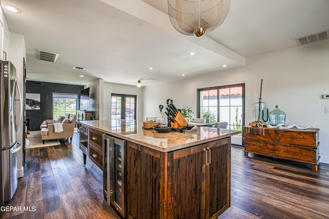 kitchen with wine cooler, visible vents, freestanding refrigerator, and open floor plan
