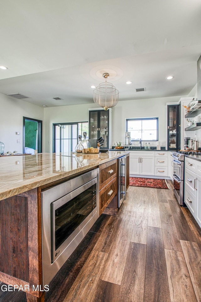 kitchen with white cabinetry, appliances with stainless steel finishes, visible vents, dark wood-style floors, and wine cooler